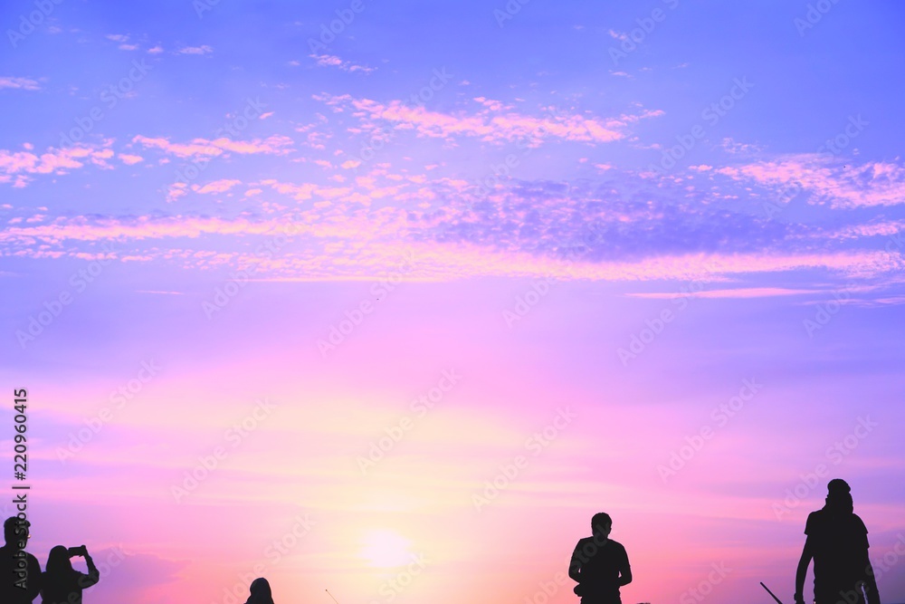 Silhouette of people in sunset background.