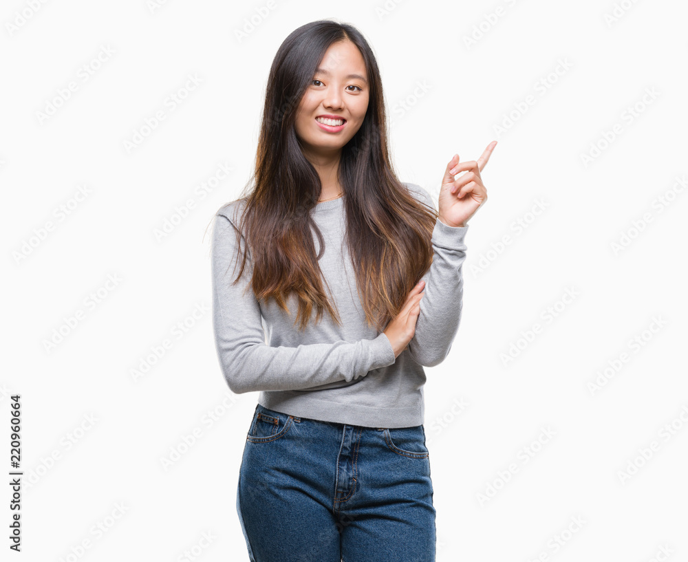 Young asian woman over isolated background with a big smile on face, pointing with hand and finger to the side looking at the camera. Young asian woman over isolated background with a big smile on face, pointing with hand and finger to the side looking at the camera.