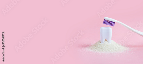 Plastic tooth and toothbrush in big pile of sugar.