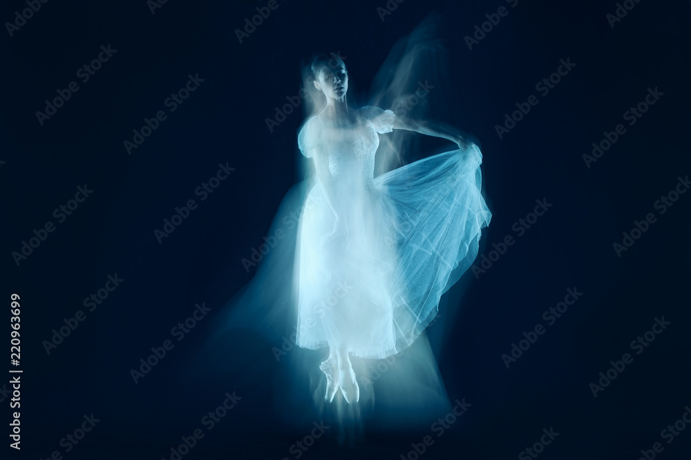 The photo as art - a sensual and emotional dance of beautiful ballerina through the veil on a dark background. A stroboscopic image of the one model The photo as art - a sensual and emotional dance of beautiful ballerina through the veil on a dark background. A stroboscopic image of the one model