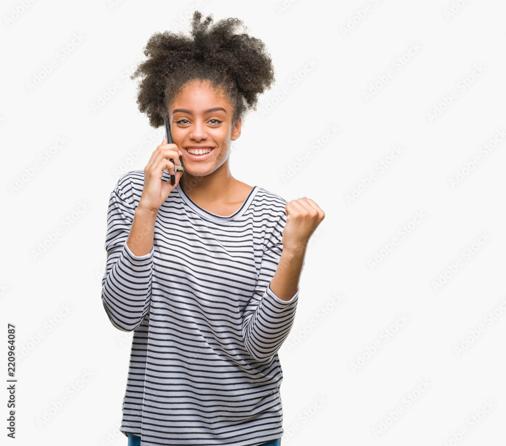 Young afro american woman talking on the phone over isolated background screaming proud and celebrating victory and success very excited, cheering emotion Young afro american woman talking on the phone over isolated background screaming proud and celebrating victory and success very excited, cheering emotion