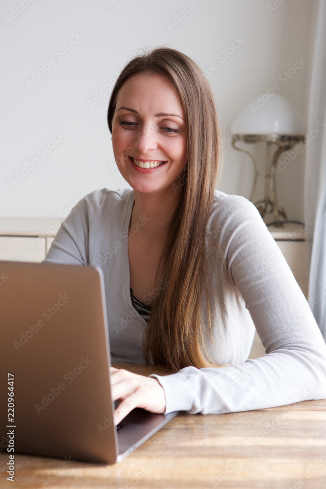 young woman sitting at home with laptop computer young woman sitting at home with laptop computer