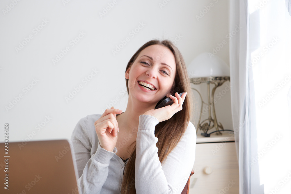 happy young woman sitting at home talking on mobile phone happy young woman sitting at home talking on mobile phone