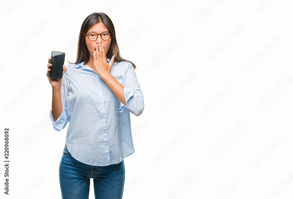 Young asian woman showing smartphone blank screen over isolated background cover mouth with hand shocked with shame for mistake, expression of fear, scared in silence, secret concept Young asian woman showing smartphone blank screen over isolated background cover mouth with hand shocked with shame for mistake, expression of fear, scared in silence, secret concept
