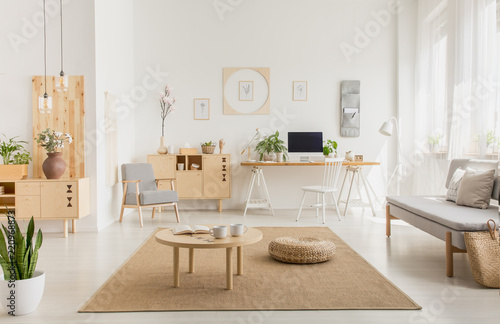 Картината върху платно Real photo of a modern home office interior with wooden furniture, coffee table,