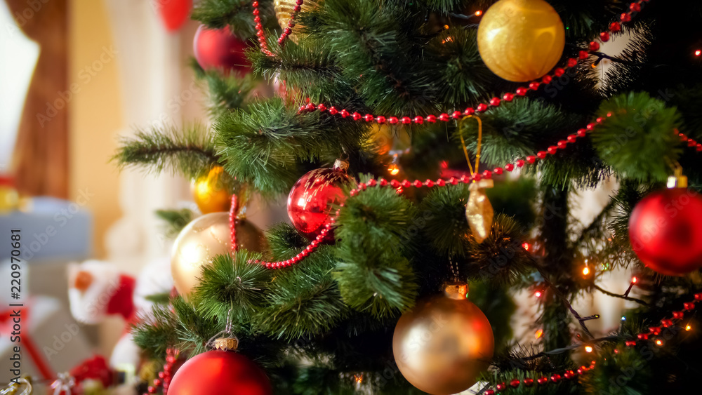 Closeup image of red and golden baubles hanging on fir tree decorated for Christmas Closeup image of red and golden baubles hanging on fir tree decorated for Christmas