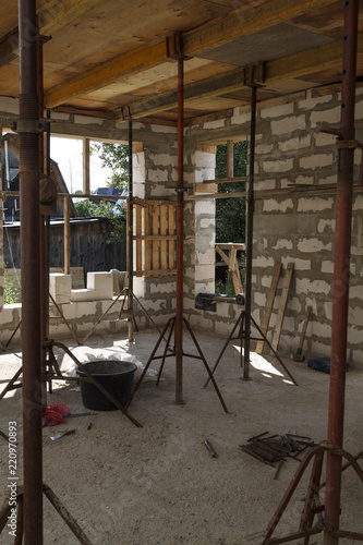 view of the wooden formwork with metal holders, which will be filled with the overlap between the floors in the country house under construction from the foam block