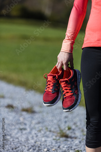 An athlete woman preparing for outdoors training with shoes in her hand  Bavarian National Forest Park  Germany