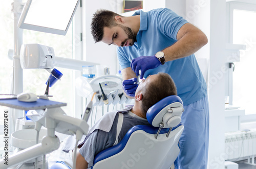 Fotografi Dentis giving anesthesia to patient