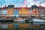 Nyhavn at sunrise, with colorful facades of old houses and old ships in the Old Town of Copenhagen, capital of Denmark.