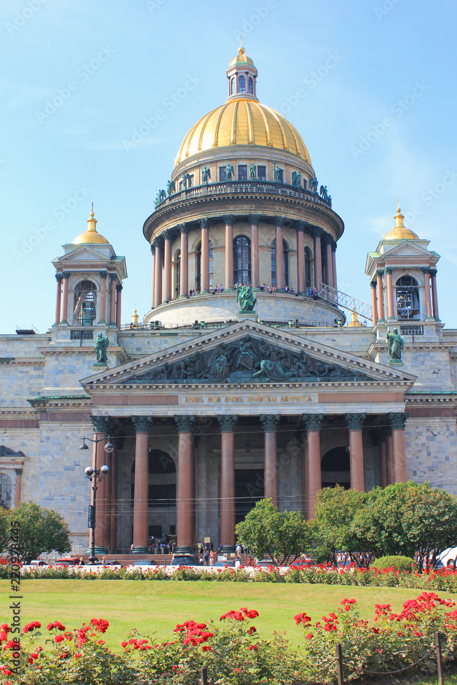 Saint Isaac's Cathedral in St. Petersburg, Russia. Church Facade Building Architecture View from Park Glade with Red Rose Flowers. Saint Isaac Cathedral City Attraction on Summer Day Background