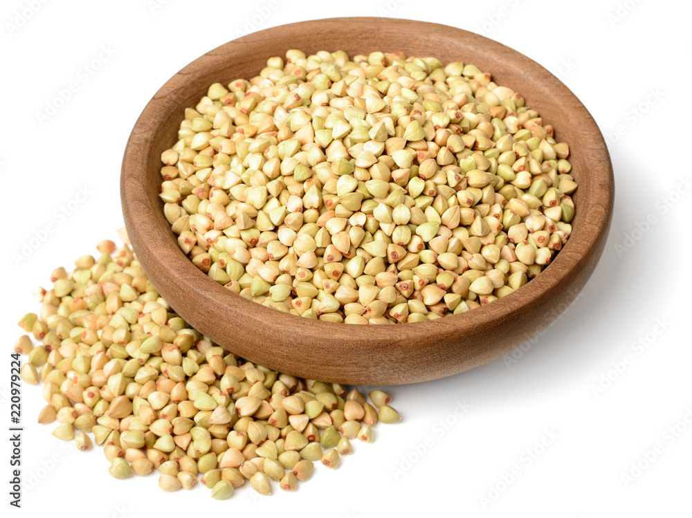 uncooked buckwheat in the wooden plate, isolated on the white background uncooked buckwheat in the wooden plate, isolated on the white background