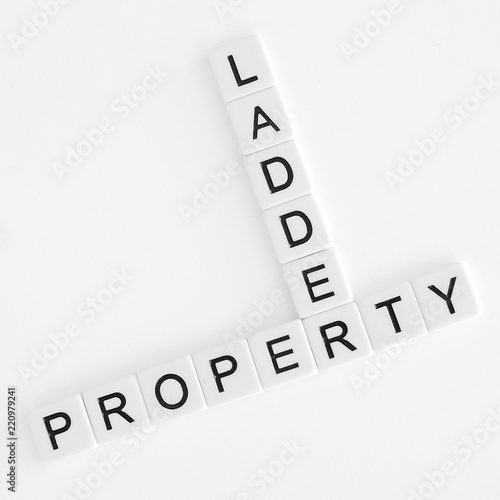 Words property and ladder in crossword style in black lettering on white tiles