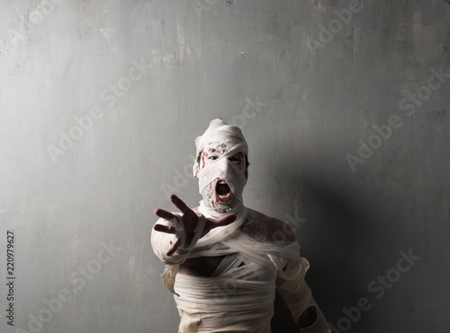Fotografia Terrorific mummy screaming on textured wall background
