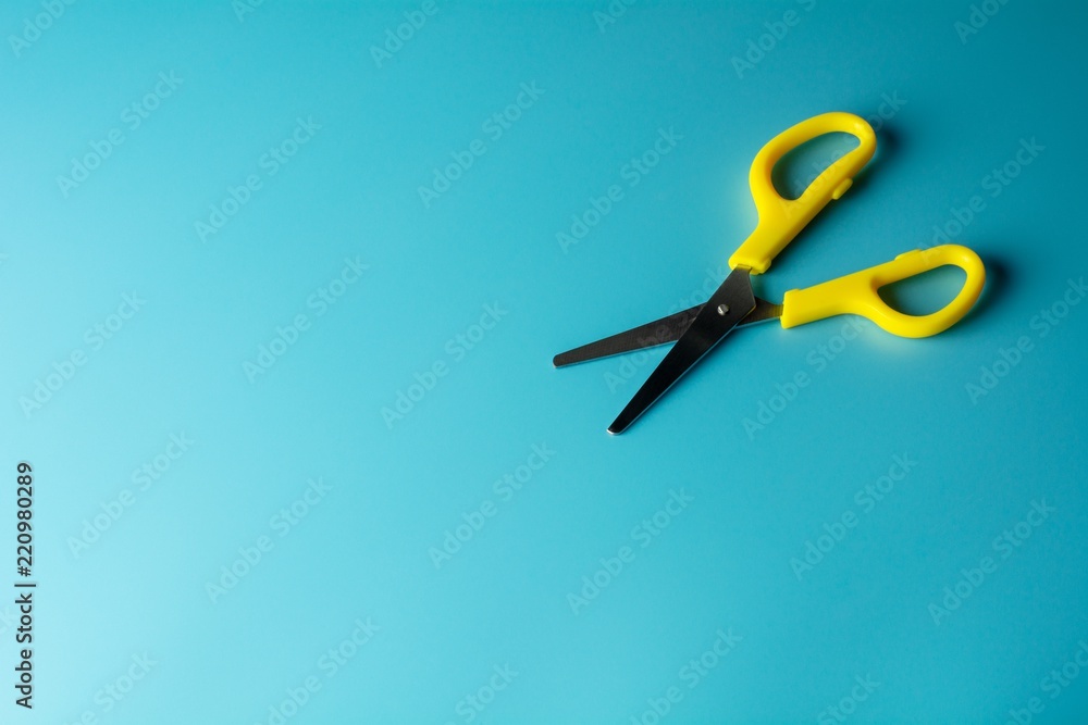yellow plastic scissors on blue paper. - background yellow plastic scissors on blue paper. - background