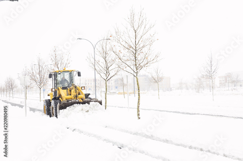 Snowplow cleaning a street in a city full of snow in winter 