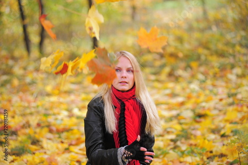 blonde in a red scarf and falling leaves