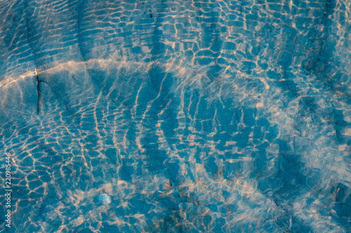 Seascape - gorgeous abstract sand pattern with wrinkly water - the bottom of the Wadden sea, the Netherlands with sunset beams photo