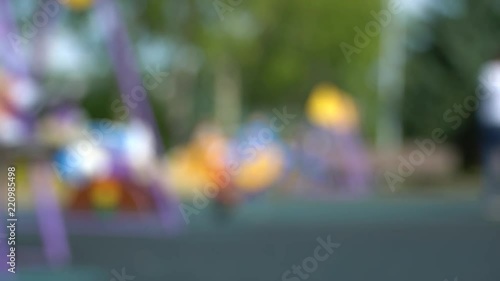 Very unfocused summer children playground with kids and parents. HD fast motion
