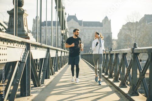 Canvas Print Young couple running in urban enviroment