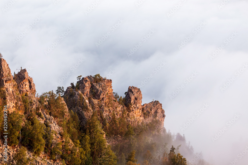 Rocks cliff with fog in mountains