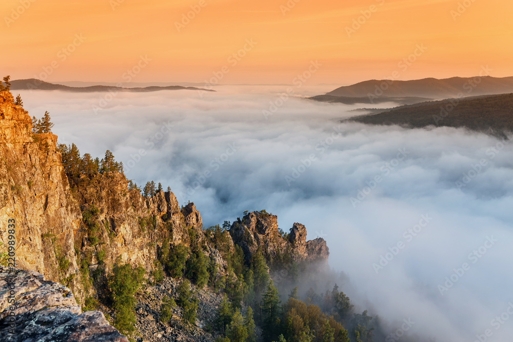 Rocks cliff with fog in mountains