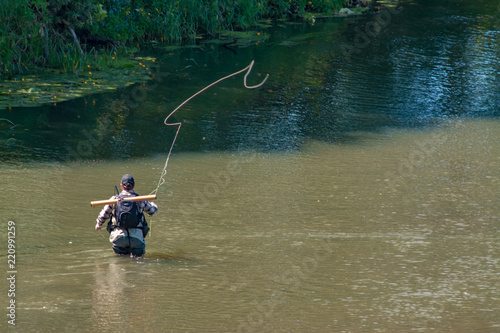The fisherman catches fish by fly fishing