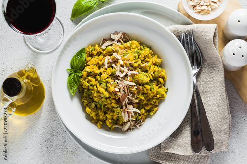 risotto with zucchini and turmeric or saffron in a plate on the table. healthy italian food