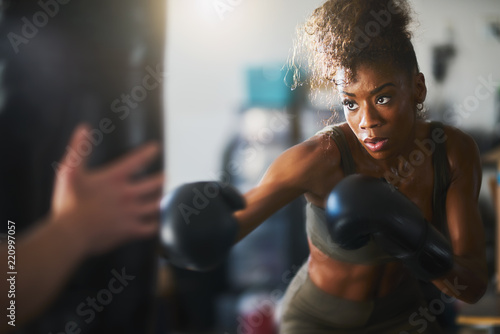 Fototapeta African American kobieta uderzające worek treningowy w domowej siłowni