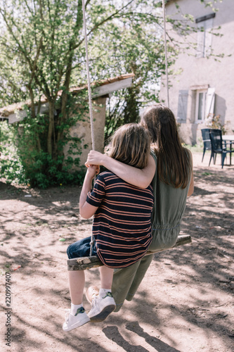 Frère et soeur sur une balançoire de dos