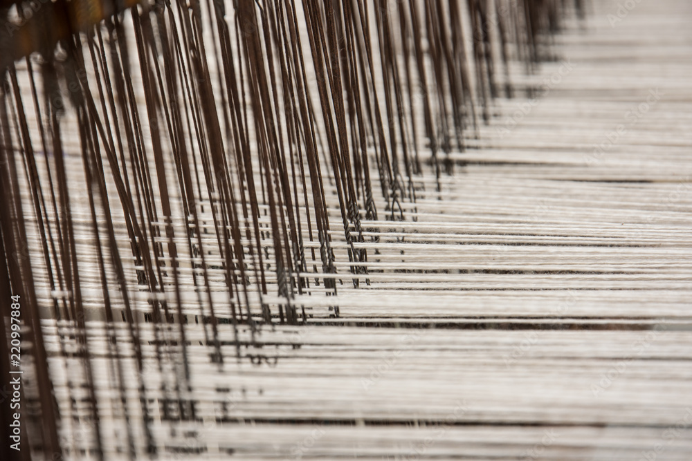 Brown and white threads in a weaving loom Brown and white threads in a weaving loom