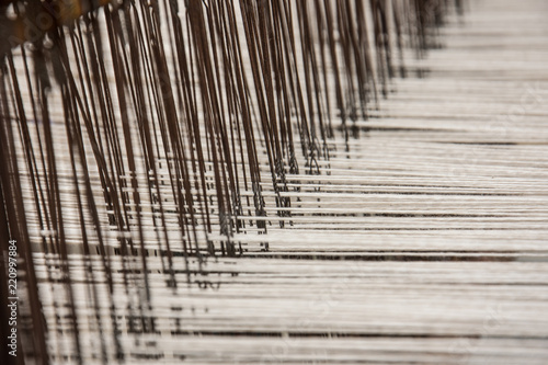 Brown and white threads in a weaving loom