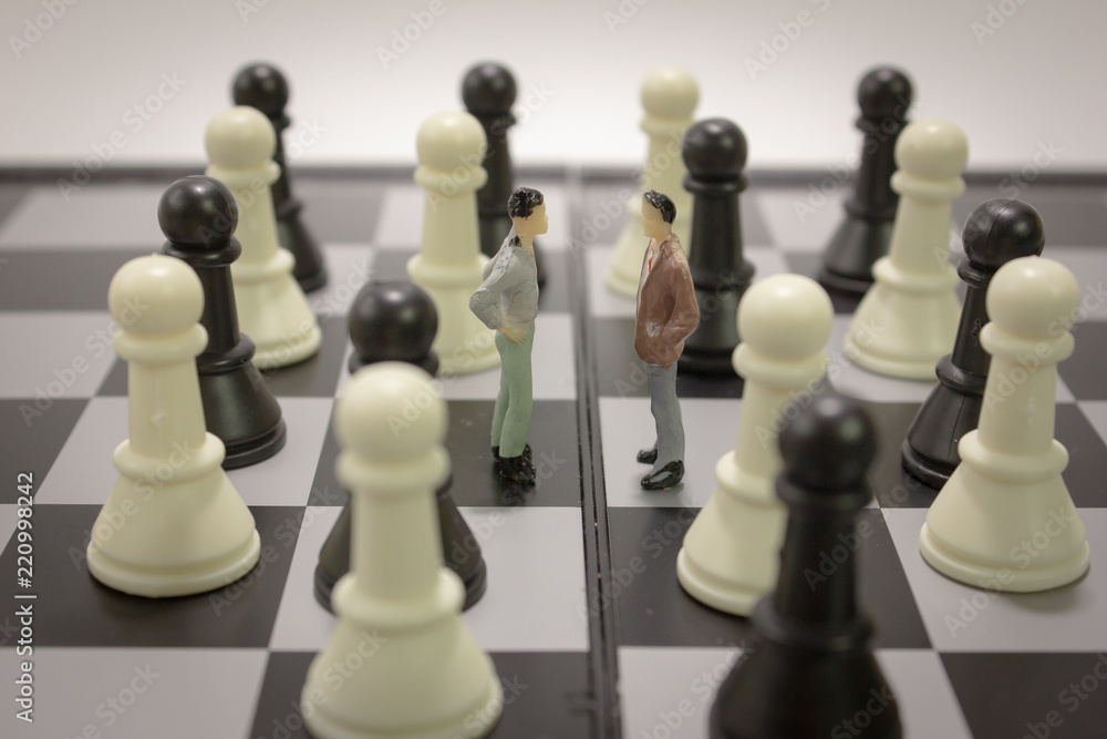 Closeup miniature businessman negotiate for cooperation on chess board with chess.