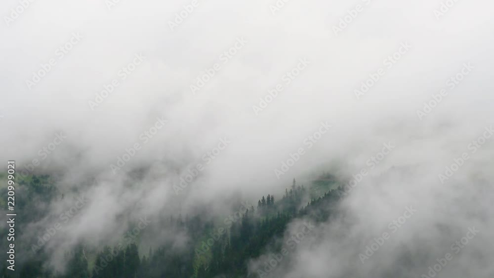 Beautiful waves of low clouds flows over the mountains. real time. Beautiful waves of low clouds flows over the mountains. real time.