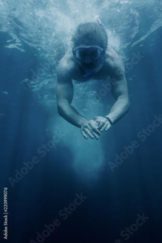 Young man snorkeling underwater.
