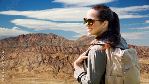 adventure, travel, tourism, hike and people concept - smiling young woman with backpack over grand canyon national park background