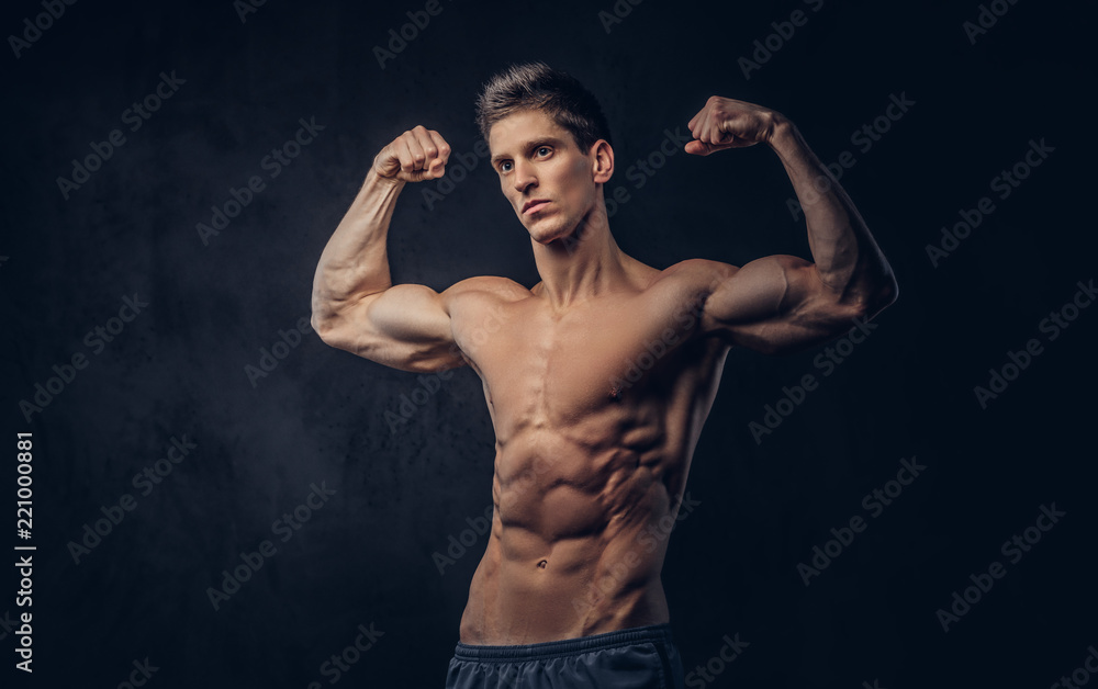 Handsome shirtless man with stylish hair and muscular ectomorph shows his biceps.