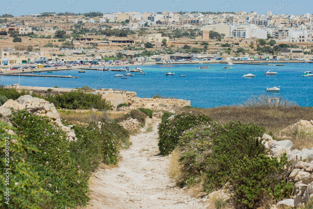 the path leading to the coastal village (Marsascala, Malta) near the Mediterranean sea under blue sky