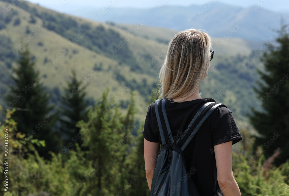 Young woman enjoying mountain view, relaxing, walking in nature. Solo traveller concept