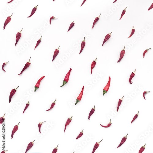 Dried chili peppers are diagonally arranged on a white background.