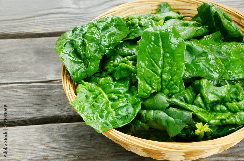 Benefits of Spinach leaves in basket on wooden floor. Benefits of Spinach leaves in basket on wooden floor.