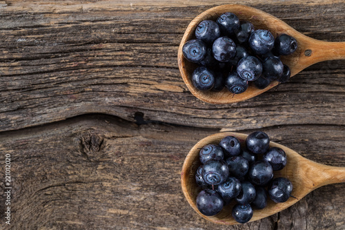 blueberry with wooden spoon on wooden table.