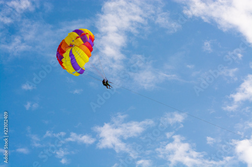 Man flying on a round bright parashute