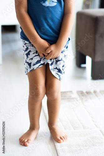 Boy with hands holding his crotch in toilet