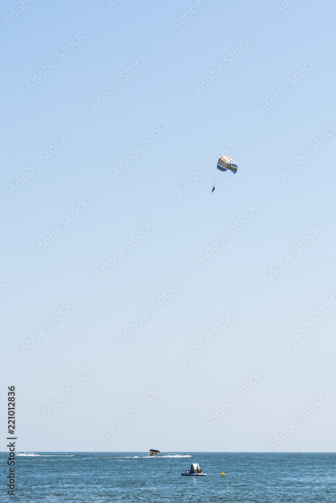human is flying on a parachute, clear sunny day with an inimitable sky, entertainment abstract background human is flying on a parachute, clear sunny day with an inimitable sky, entertainment abstract background