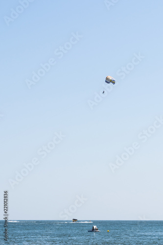 human is flying on a parachute, clear sunny day with an inimitable sky, entertainment abstract background