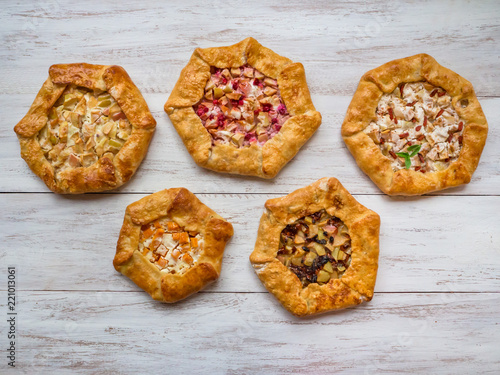 Pattern of different handmade pies on a white wooden table. 