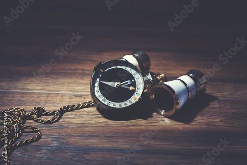 Binocle with compass on wooden background photo