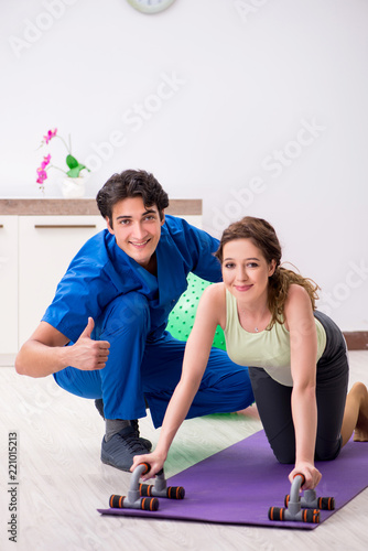 Fitness instructor helping sportsman during exercise