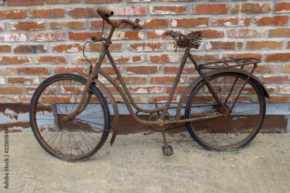 rusty bike in front of brick wall rusty bike in front of brick wall